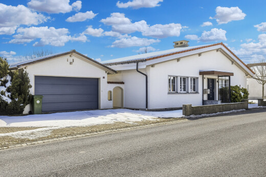façade avec day time, property visible, bardage en stuc, et garage attaché