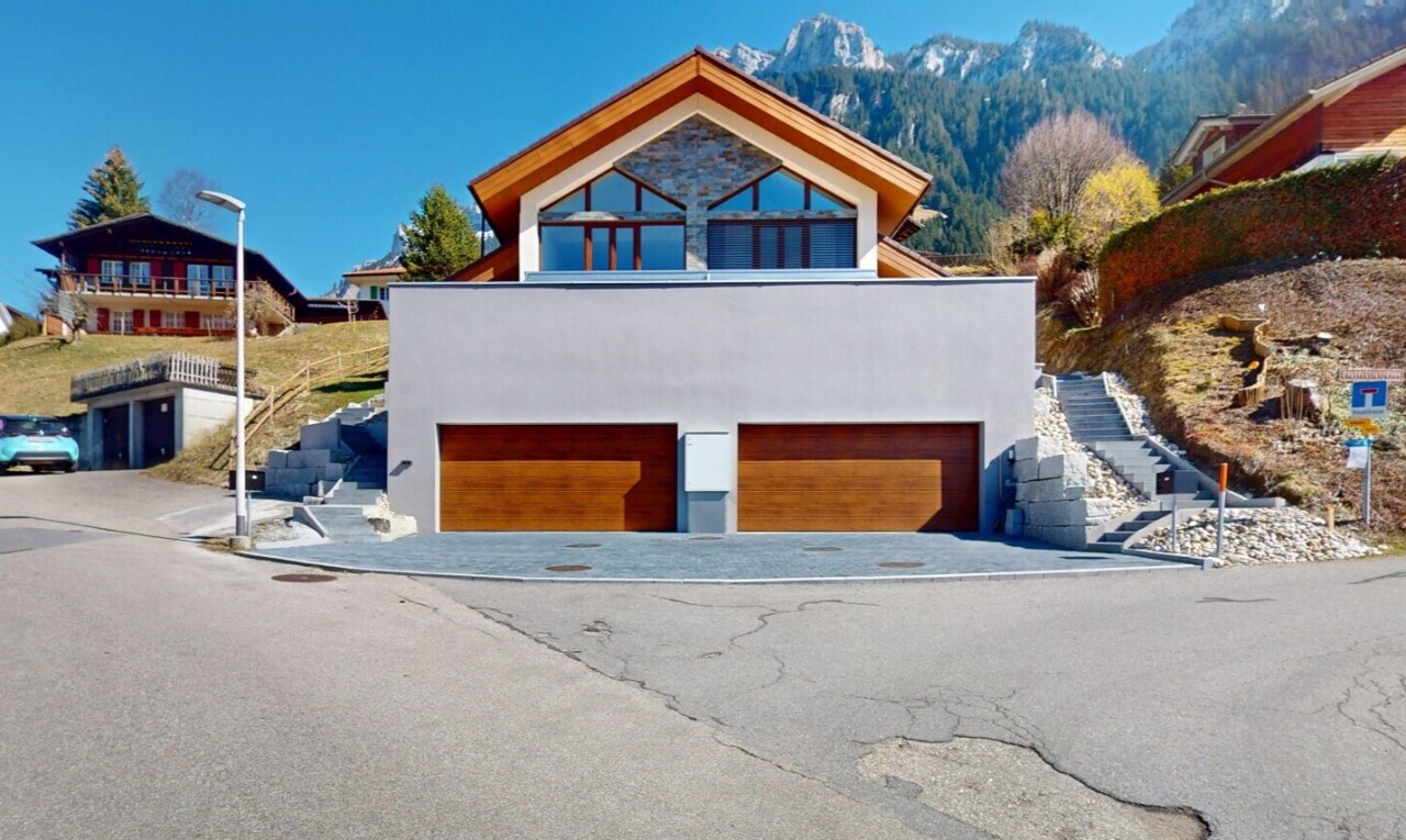 façade avec vue sur la montagne, garage intégré, allée, et bardage en stuc