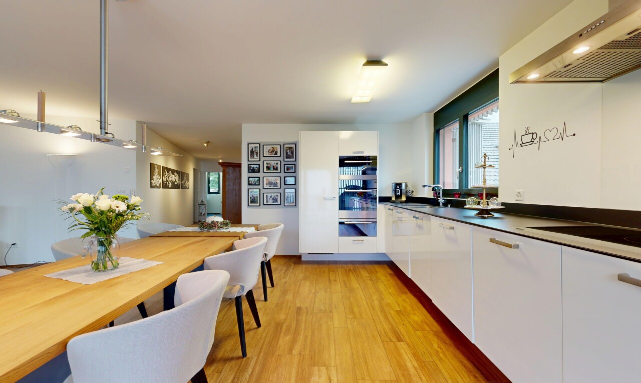 cuisine avec hotte, armoires à panneau plat, sol en finition bois, wood finish floor, et inside property