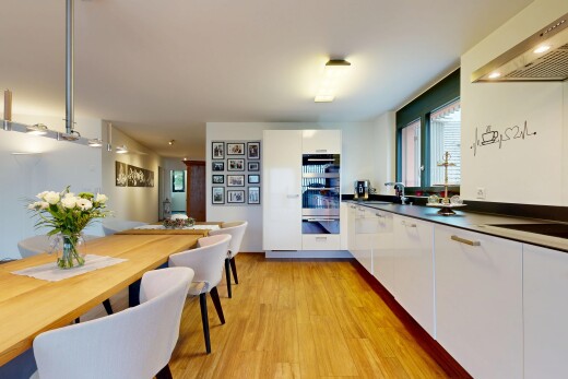 cuisine avec hotte, armoires à panneau plat, sol en finition bois, wood finish floor, et inside property