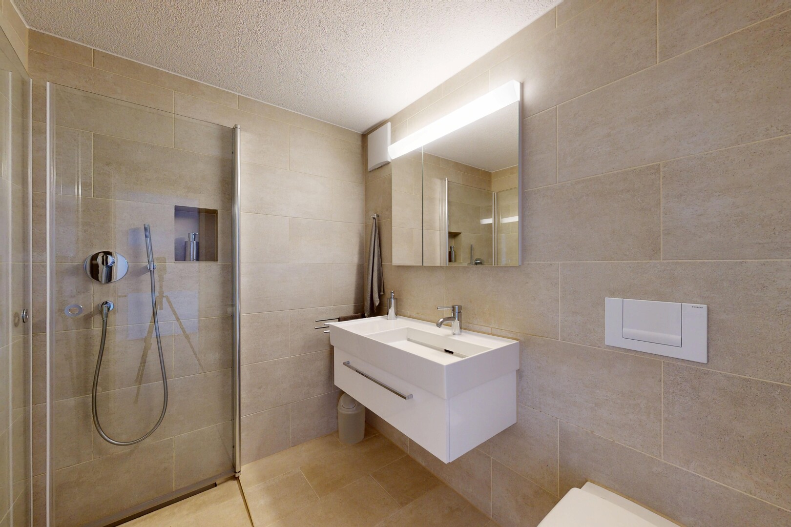 salle de bains avec mur en carrelage, tile wall, lavabo (ou coiffeuse selon le contexte), miroir, et salle de bain complète
