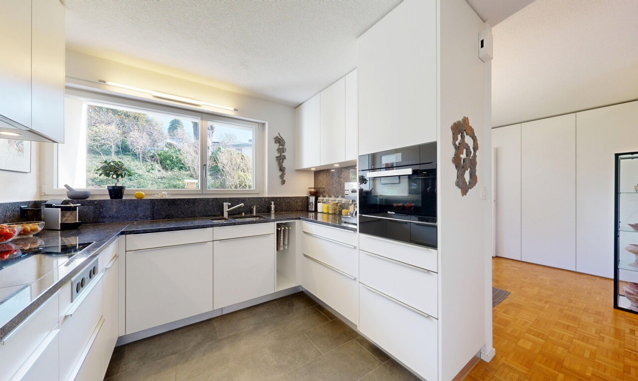 cuisine avec armoires blanches, white cabinets, dark countertops, four, et lumière naturelle