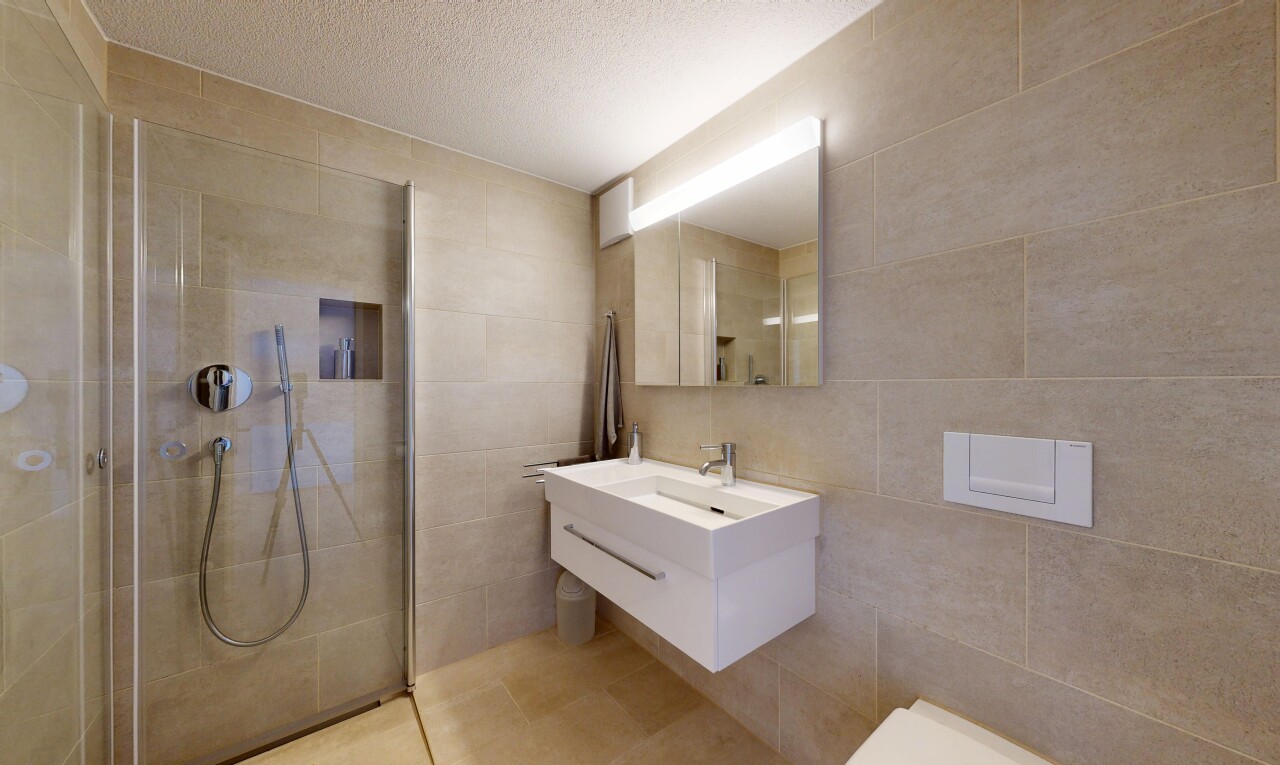 salle de bains avec mur en carrelage, tile wall, lavabo (ou coiffeuse selon le contexte), miroir, et salle de bain complète