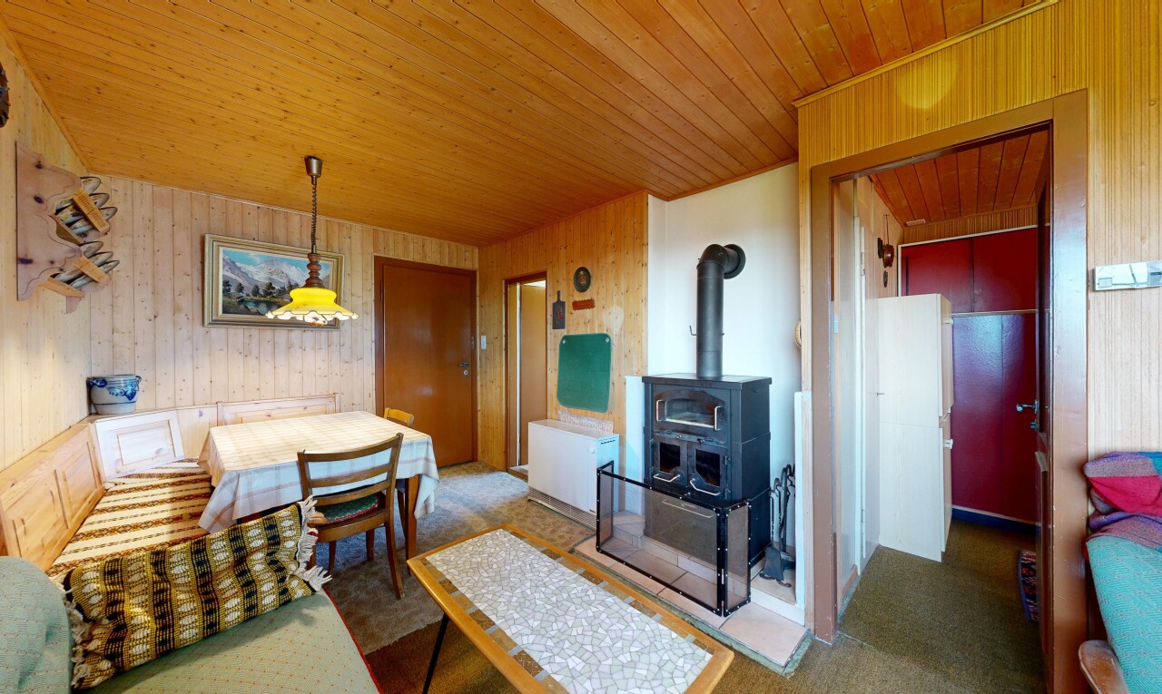 wohn- / esszimmer mit teppich, carpet, holzofen, inside property, und holzwand