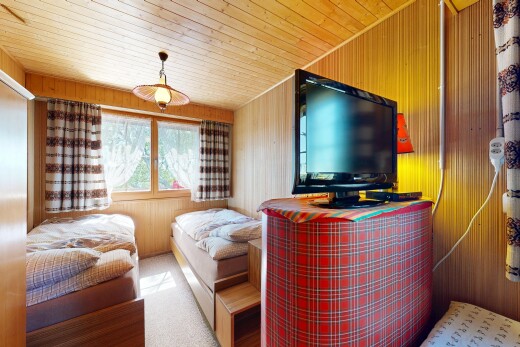 salon avec télévision, lumière naturelle, natural light, inside property, et mur en bois