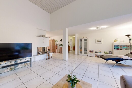 living room with light tile patterned floors and high vaulted ceiling