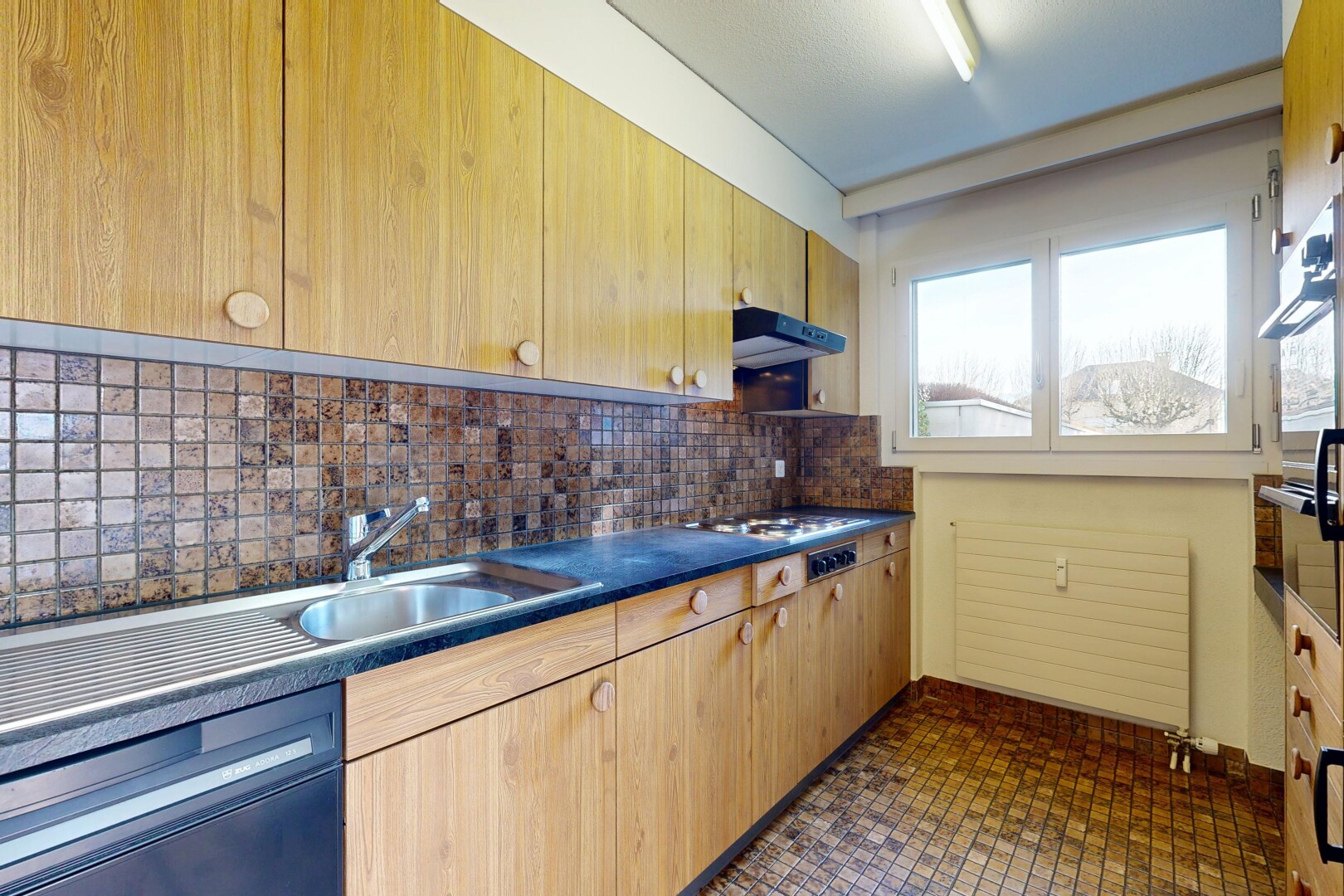 cuisine avec plans de travail, inside property, dosseret, backsplash, et armoires marron clair