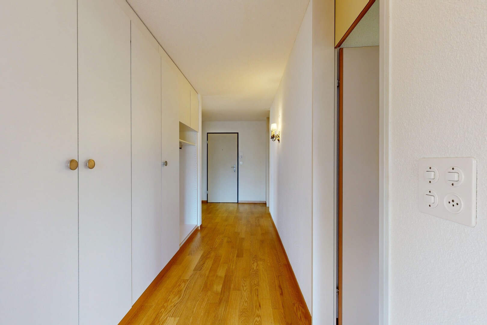 couloir avec inside property, sol en finition bois, wood finish floor, cloison sèche, et drywall