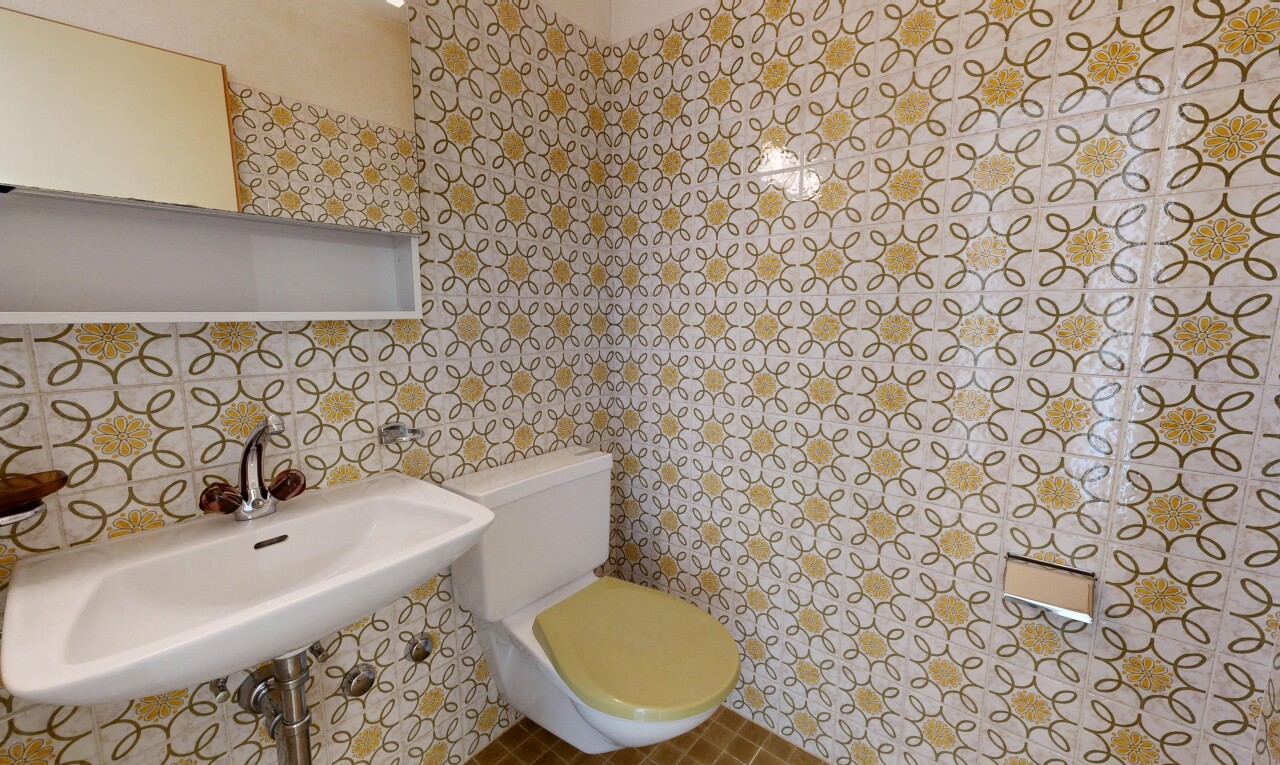 salle de bains avec toilette, miroir, évier, inside property, et mur en carrelage