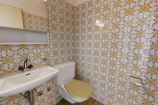 salle de bains avec toilette, miroir, évier, inside property, et mur en carrelage
