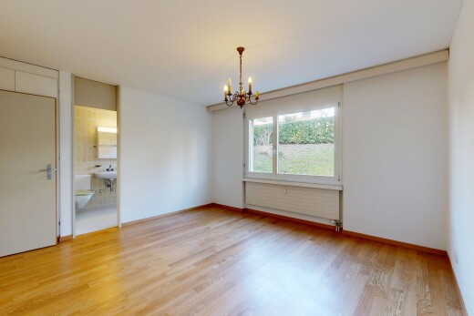 pièce vide avec inside property, sol en finition bois, wood finish floor, lustre remarquable, et lumière naturelle