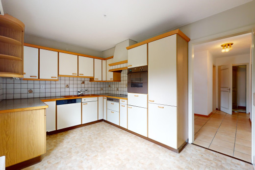 küche mit ofen, küchenrückwand beim herd, weiße schränke, geschirrspülmaschine, und offene regale