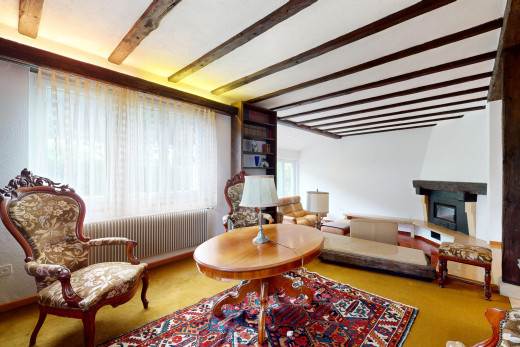 wohnzimmer mit balkendecke, teppich, kamin, natürliches licht, und kühler