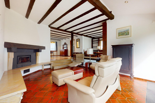 wohnzimmer mit dachschräge, balkendecke, kamin, und natürliches licht