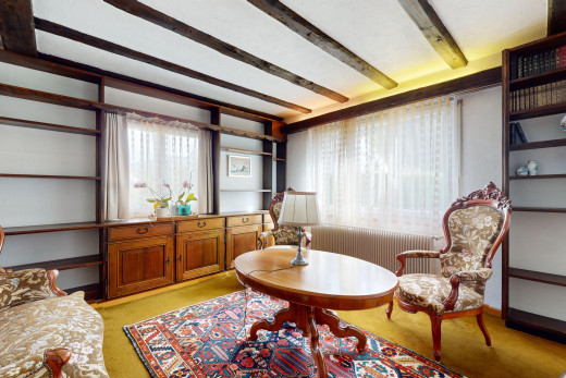 wohnzimmer mit balkendecke, teppich, und natürliches licht