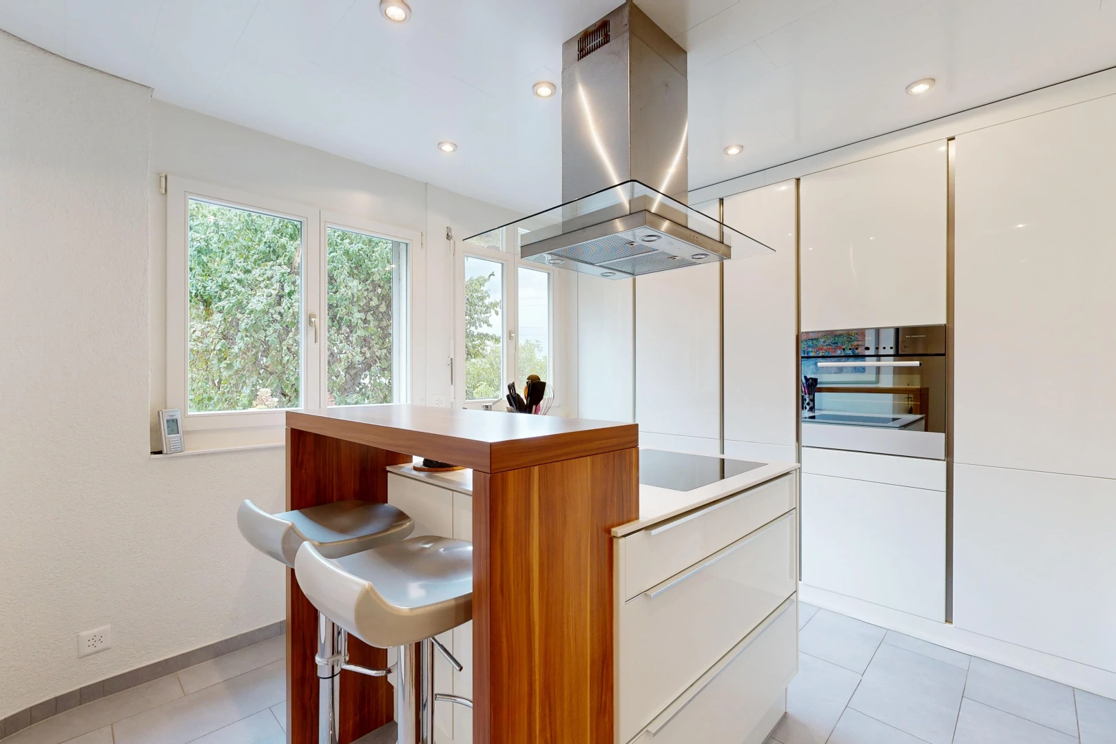 cuisine avec hotte, four, light floor, éclairage encastré, et flat panel cabinets
