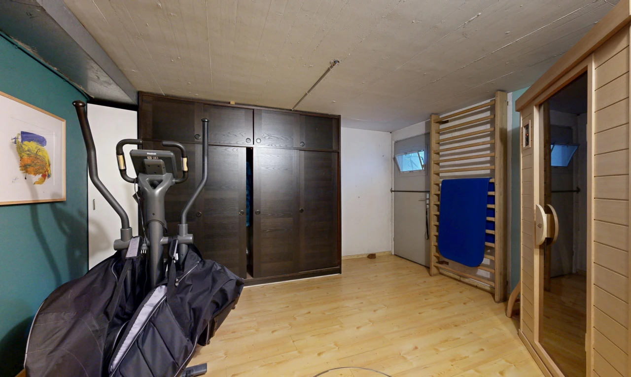 gym avec low ceiling, plafond bas, wood finish floor, sol en finition bois, et inside property