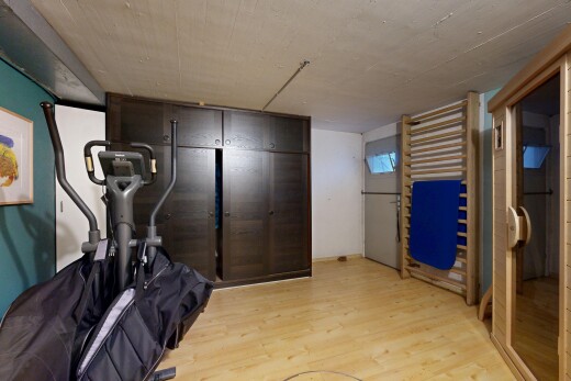 gym avec low ceiling, plafond bas, wood finish floor, sol en finition bois, et inside property