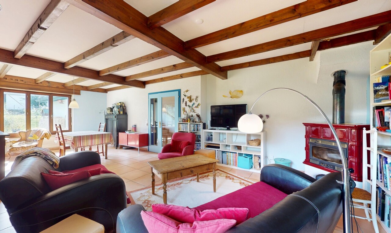 salon avec inside property, beamed ceiling, plafond à poutres, drywall, et cloison sèche