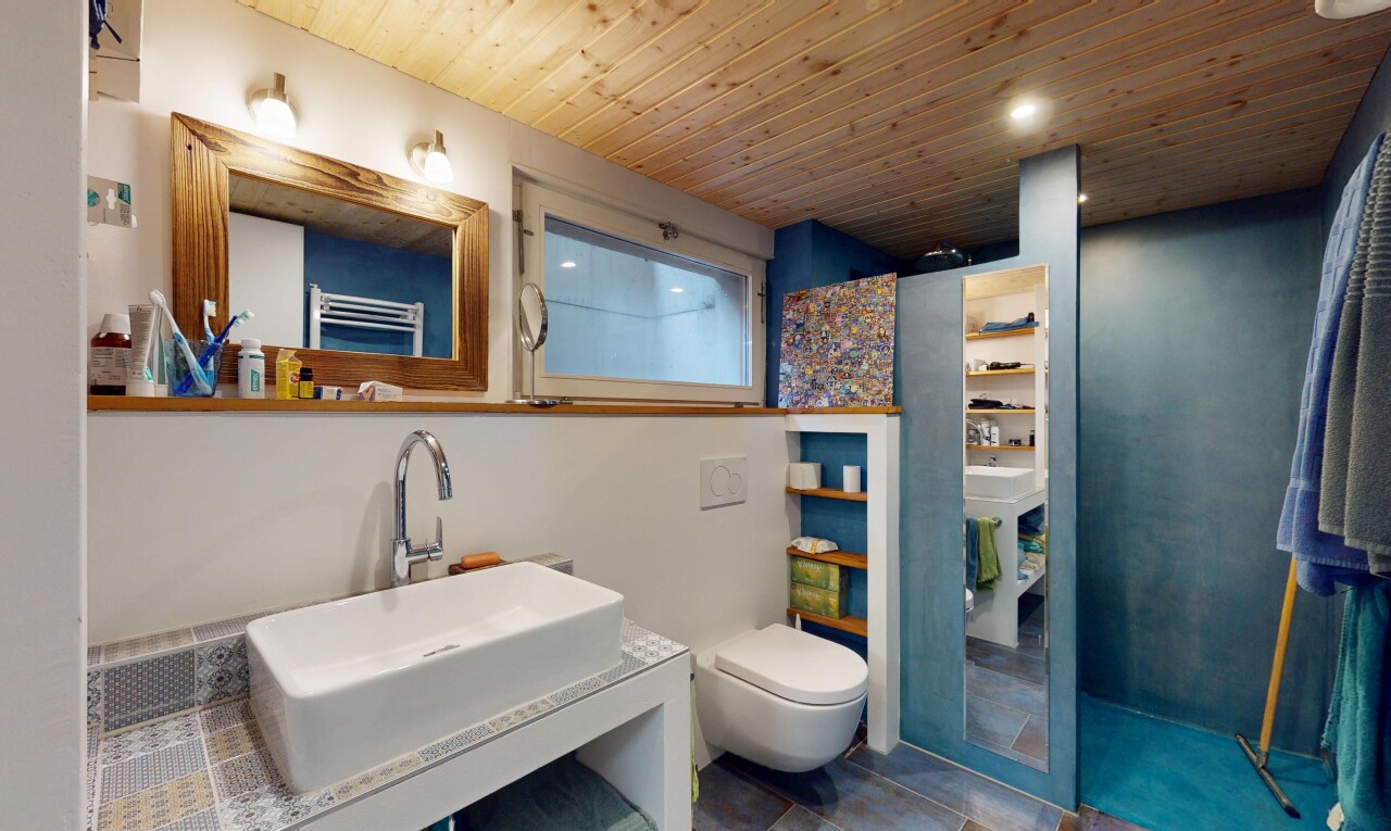 salle de bains avec miroir, chauffe-serviettes, évier, inside property, et toilette