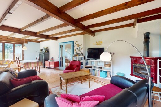living room with beamed ceiling, tile patterned flooring, and a wood stove
