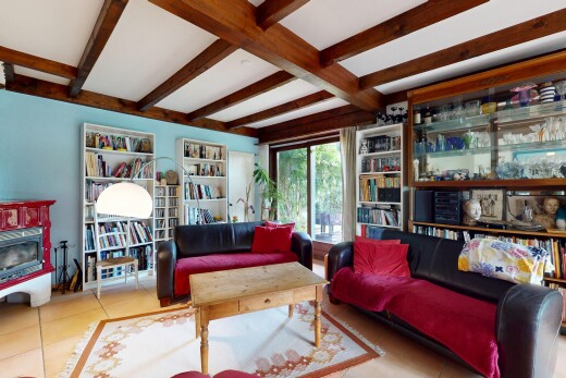 living room with beamed ceiling and tile patterned flooring