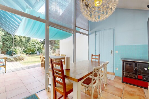dining space featuring light tile patterned floors, a chandelier, expansive windows, and wainscoting