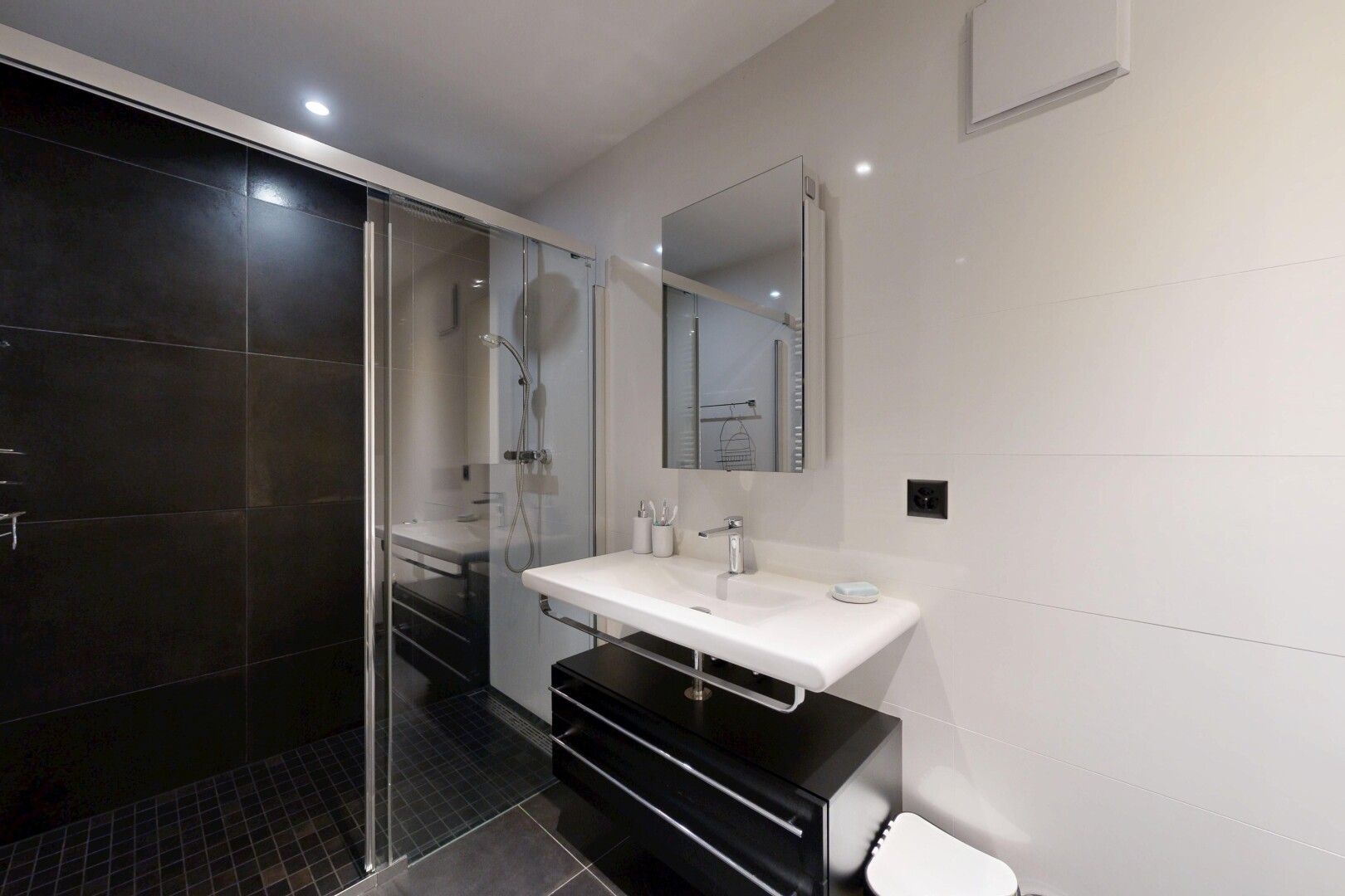 full bathroom with a stall shower, dark tile patterned floors, and vanity