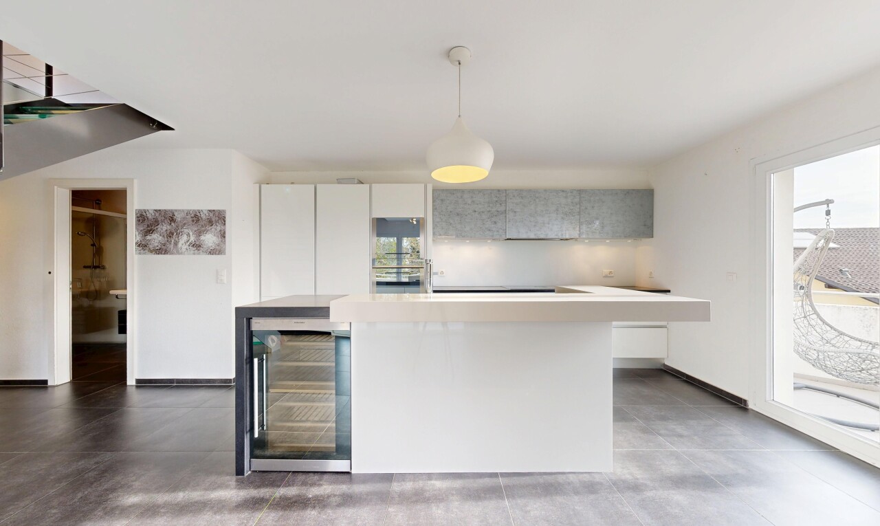 kitchen with wine cooler, hanging light fixtures, modern cabinets, light countertops, and a kitchen island