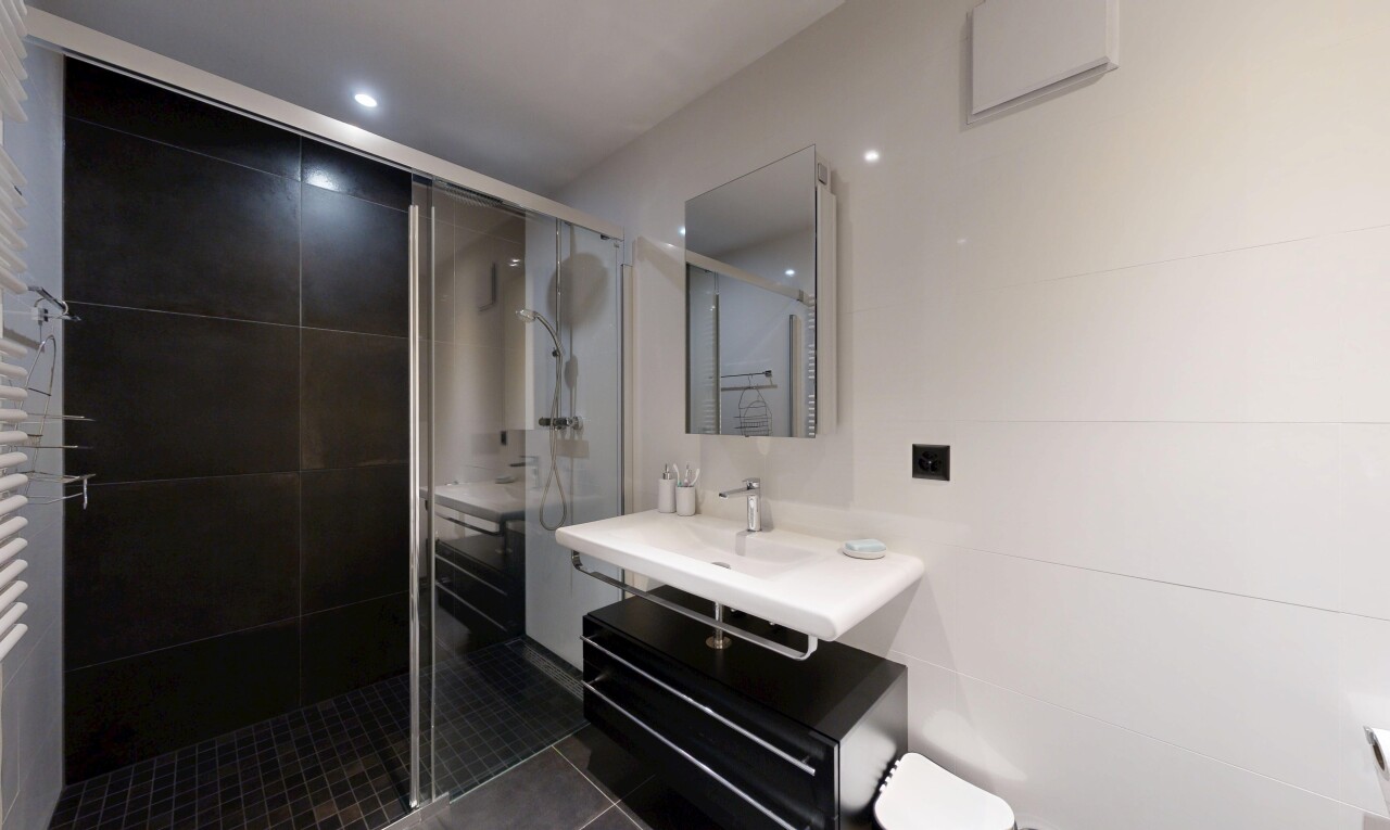 full bathroom with a stall shower, dark tile patterned floors, and vanity
