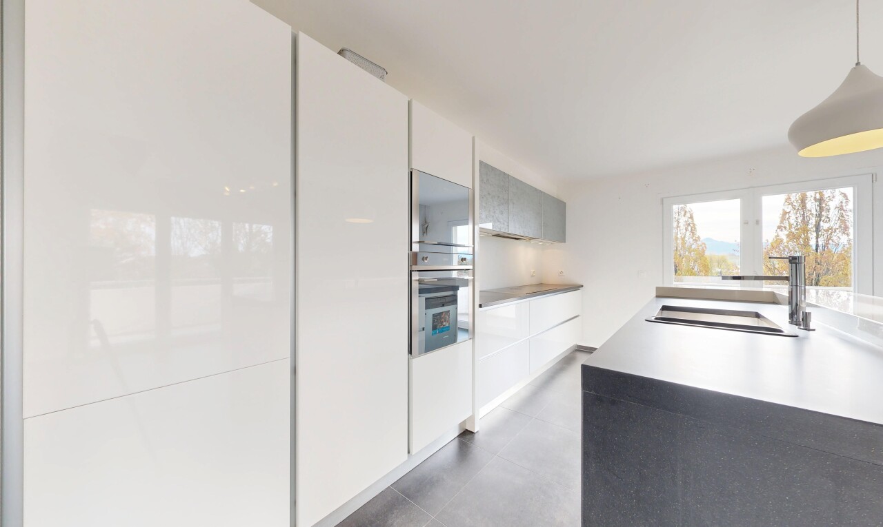 kitchen featuring modern cabinets, stainless steel oven, light countertops, and concrete flooring