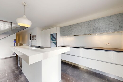 cuisine avec éclairage suspendu, armoires blanches, inside property, armoires à panneau plat, et îlot de cuisine