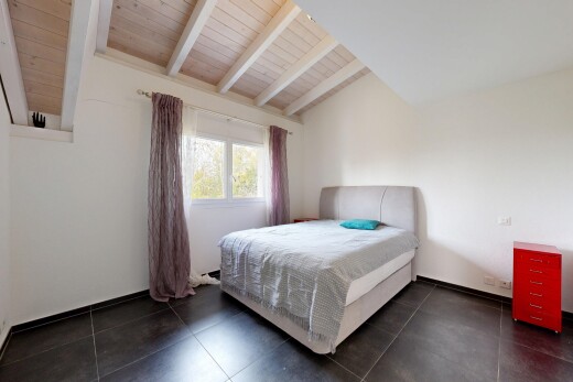 chambre avec beamed ceiling, plafond à poutres, drywall, cloison sèche, et natural light