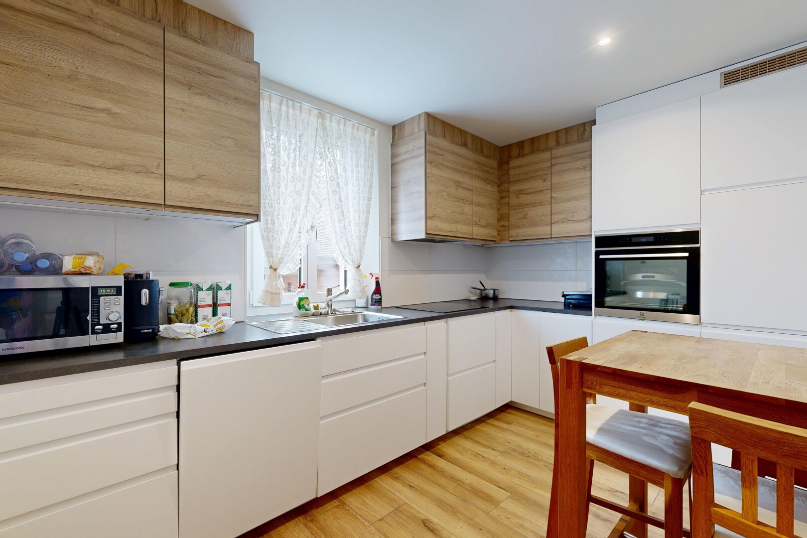 cuisine avec white cabinets, armoires blanches, lumière naturelle, two tone kitchen, et micro-ondes