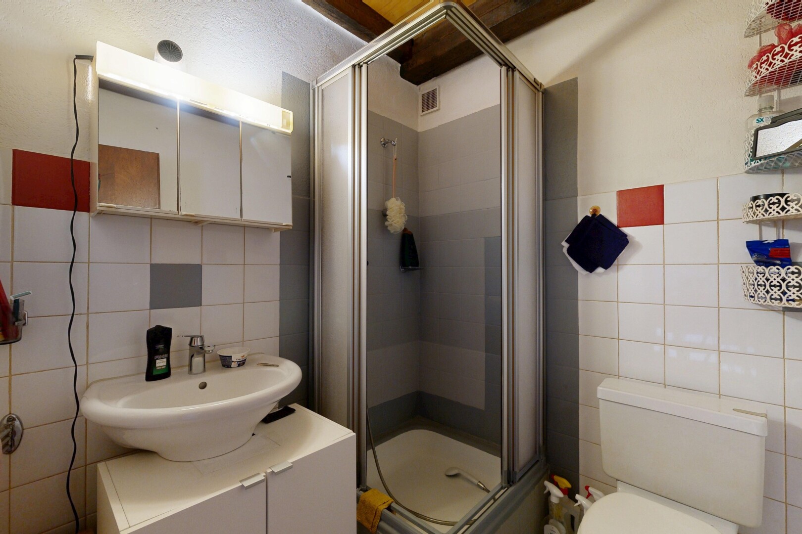 salle de bains avec mur en carrelage, tile wall, douche, miroir, et salle de bain complète