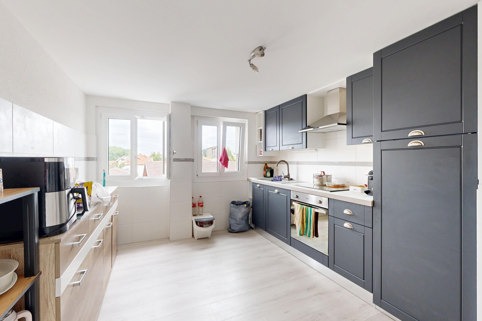cuisine avec hotte, light floor, light countertops, plans de travail, et lumière naturelle