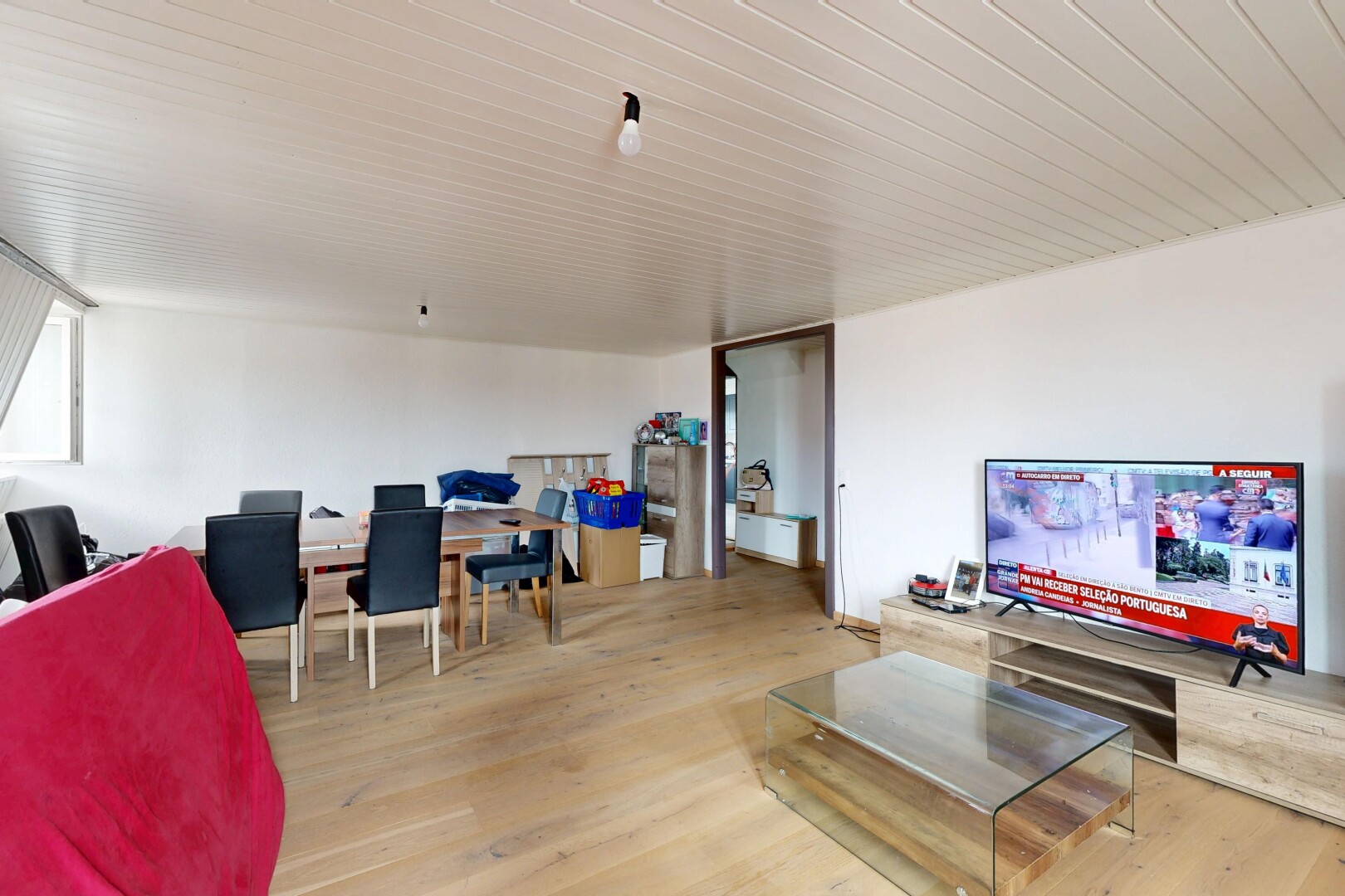 salon / salle à manger avec télévision, cloison sèche, drywall, sol en finition bois, et wood finish floor