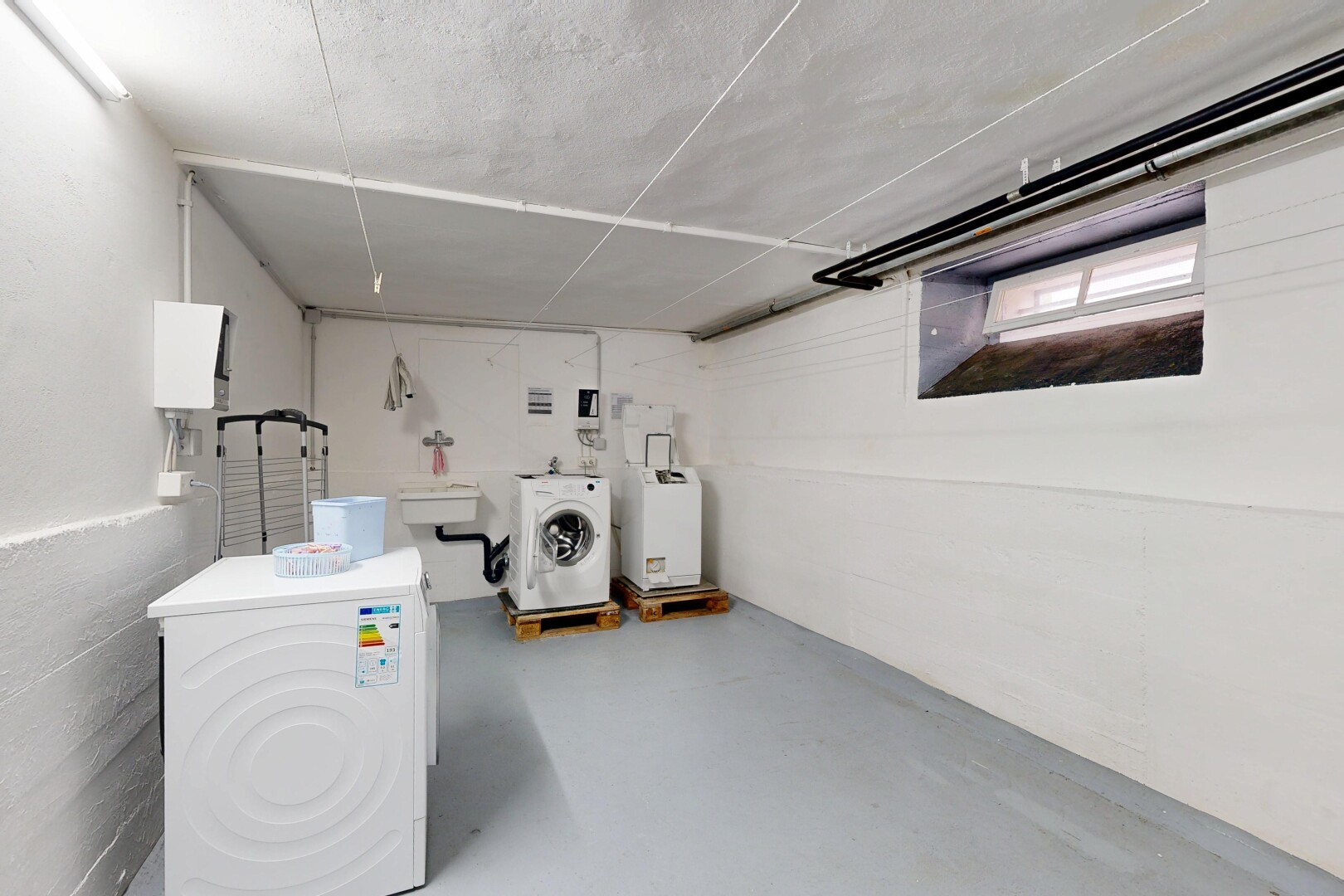 buanderie avec lave-linge et sèche-linge, concrete floor, sol en béton, inside property, et finished concrete floor