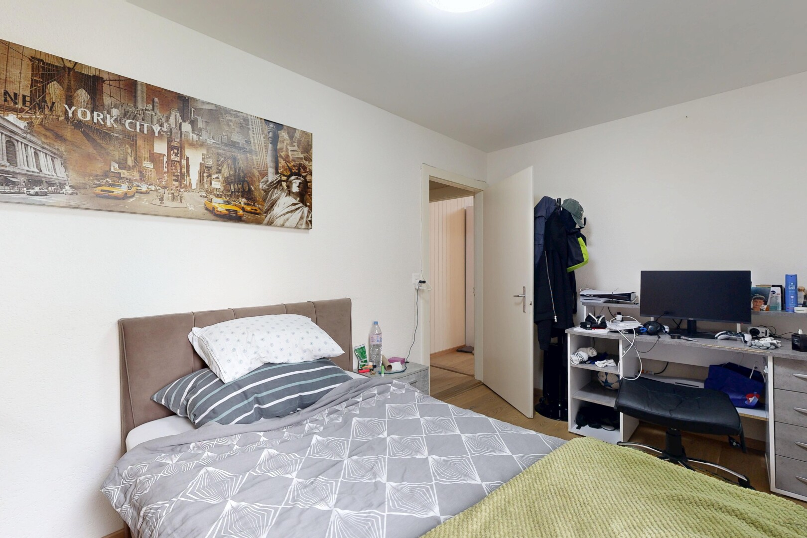 chambre avec cloison sèche, drywall, télévision, et espace bureau