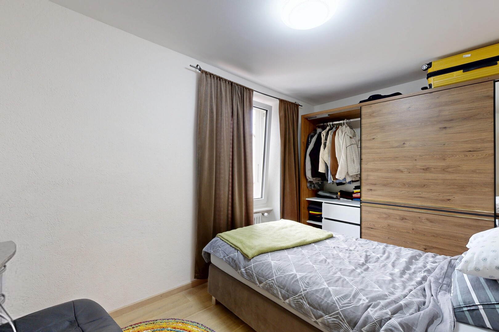 chambre avec porte de grange, lumière naturelle, sol en finition bois, wood finish floor, et inside property