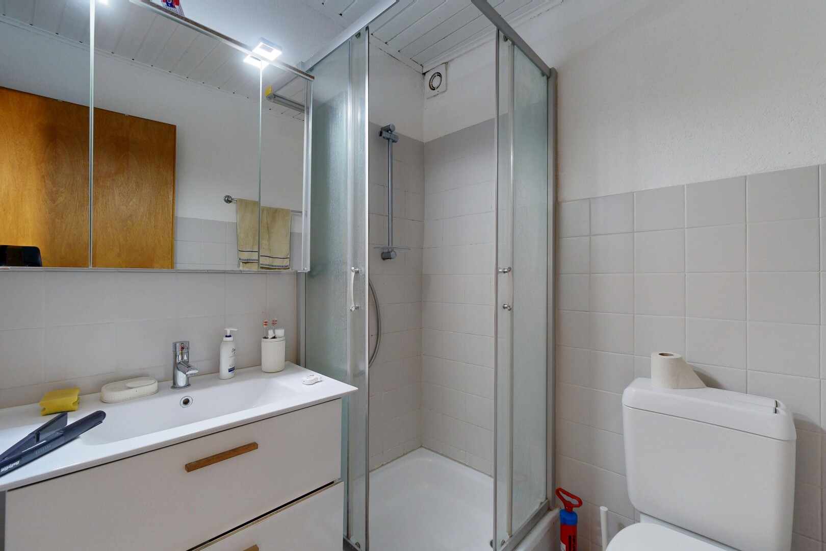 salle de bains avec lavabo (ou coiffeuse selon le contexte), salle de bain complète, douche, miroir, et tile wall