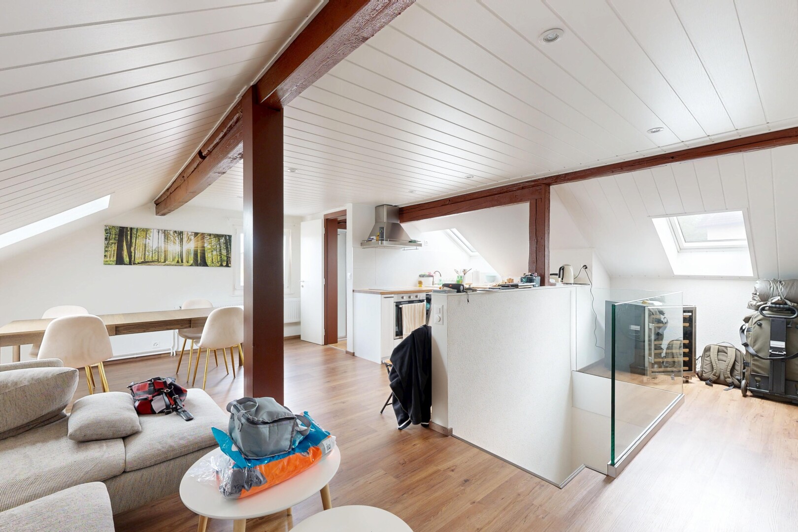 salon / salle à manger avec vaulted ceiling, plafond voûté, puits de lumière, wood finish floor, et sol en finition bois