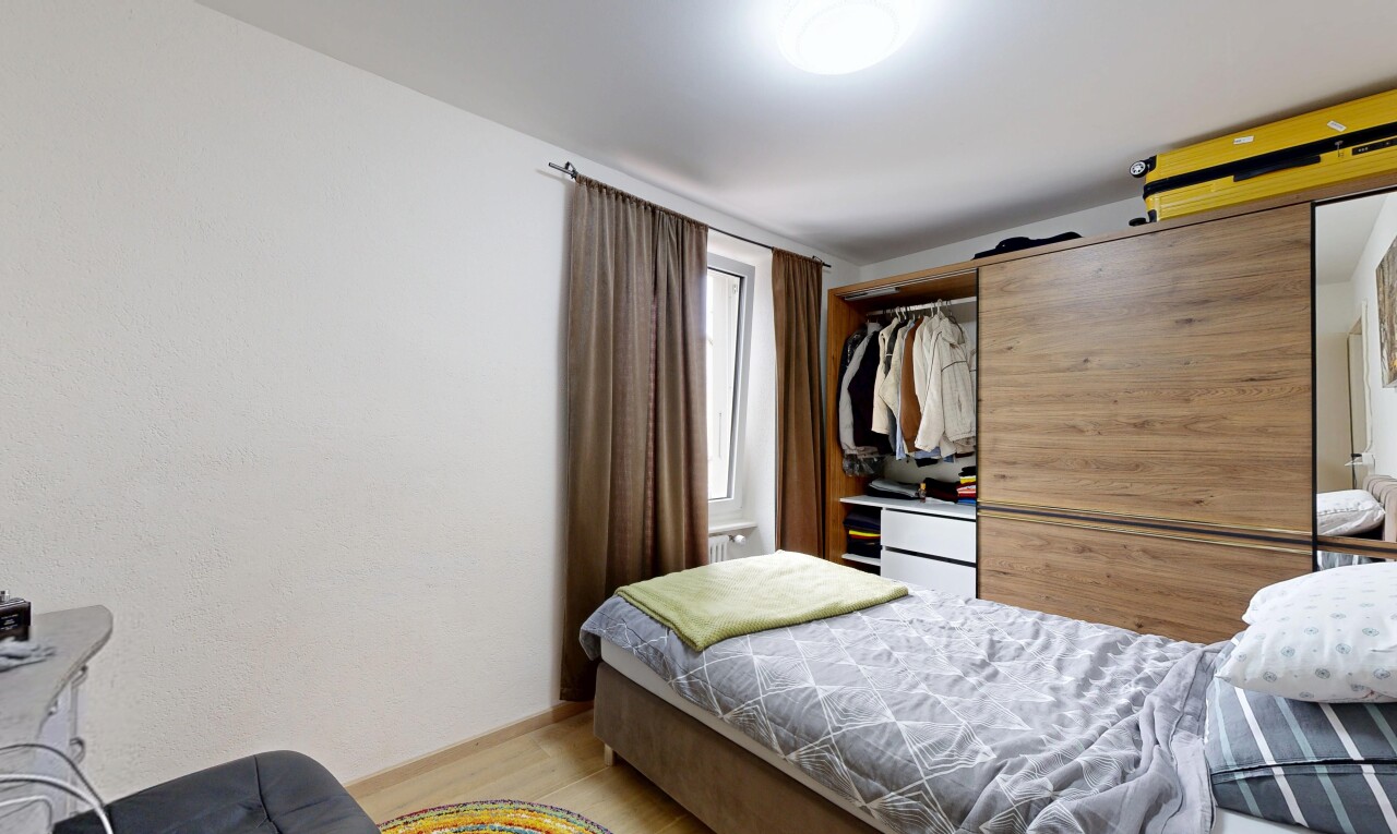 chambre avec porte de grange, lumière naturelle, sol en finition bois, wood finish floor, et inside property
