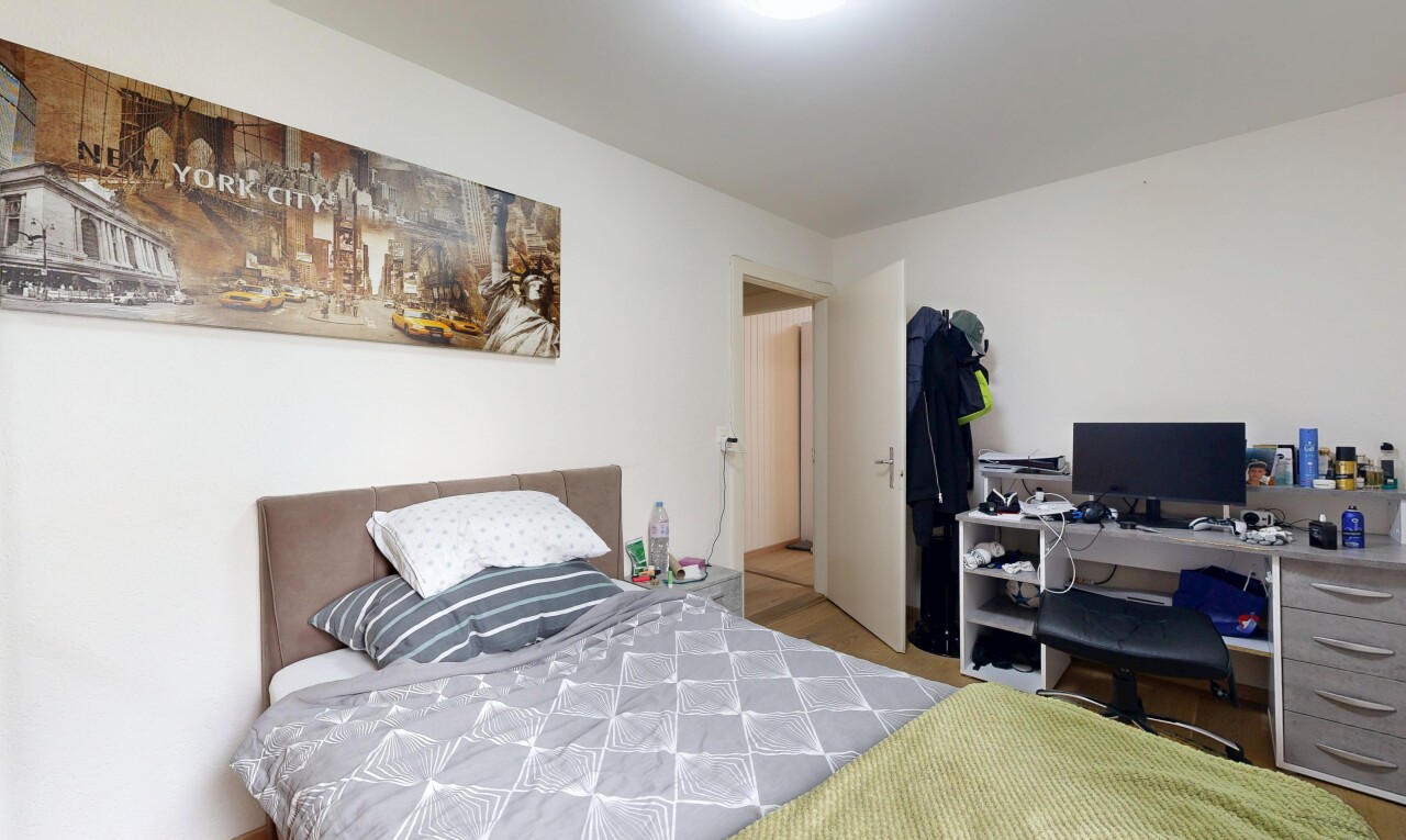 chambre avec cloison sèche, drywall, télévision, et espace bureau