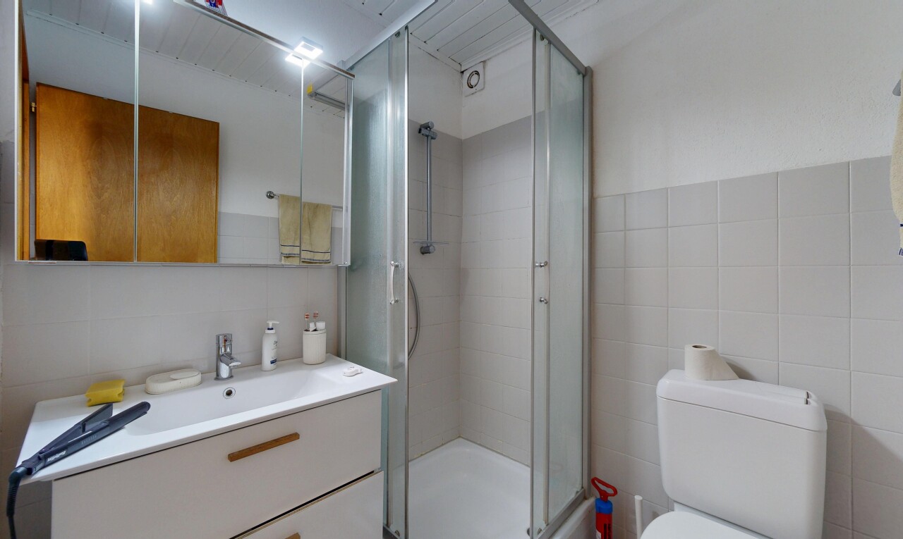 salle de bains avec lavabo (ou coiffeuse selon le contexte), salle de bain complète, douche, miroir, et tile wall