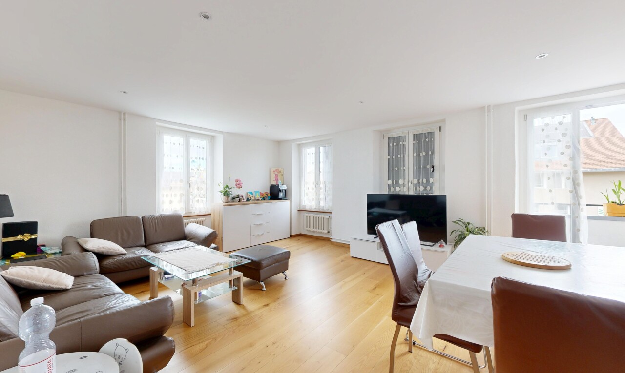 salon / salle à manger avec lumière naturelle, télévision, sol en finition bois, wood finish floor, et cloison sèche