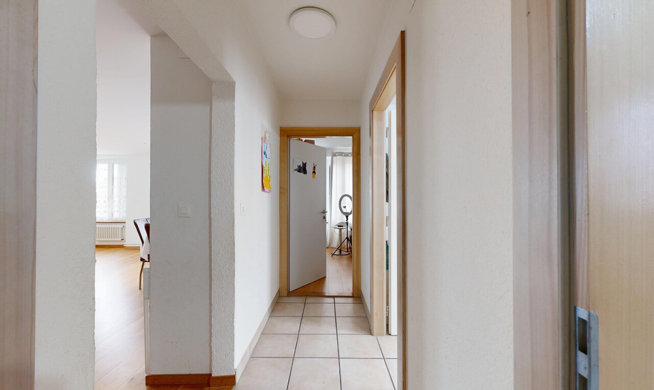 couloir avec inside property, light floor, tile floor, sol en carrelage, et radiateur