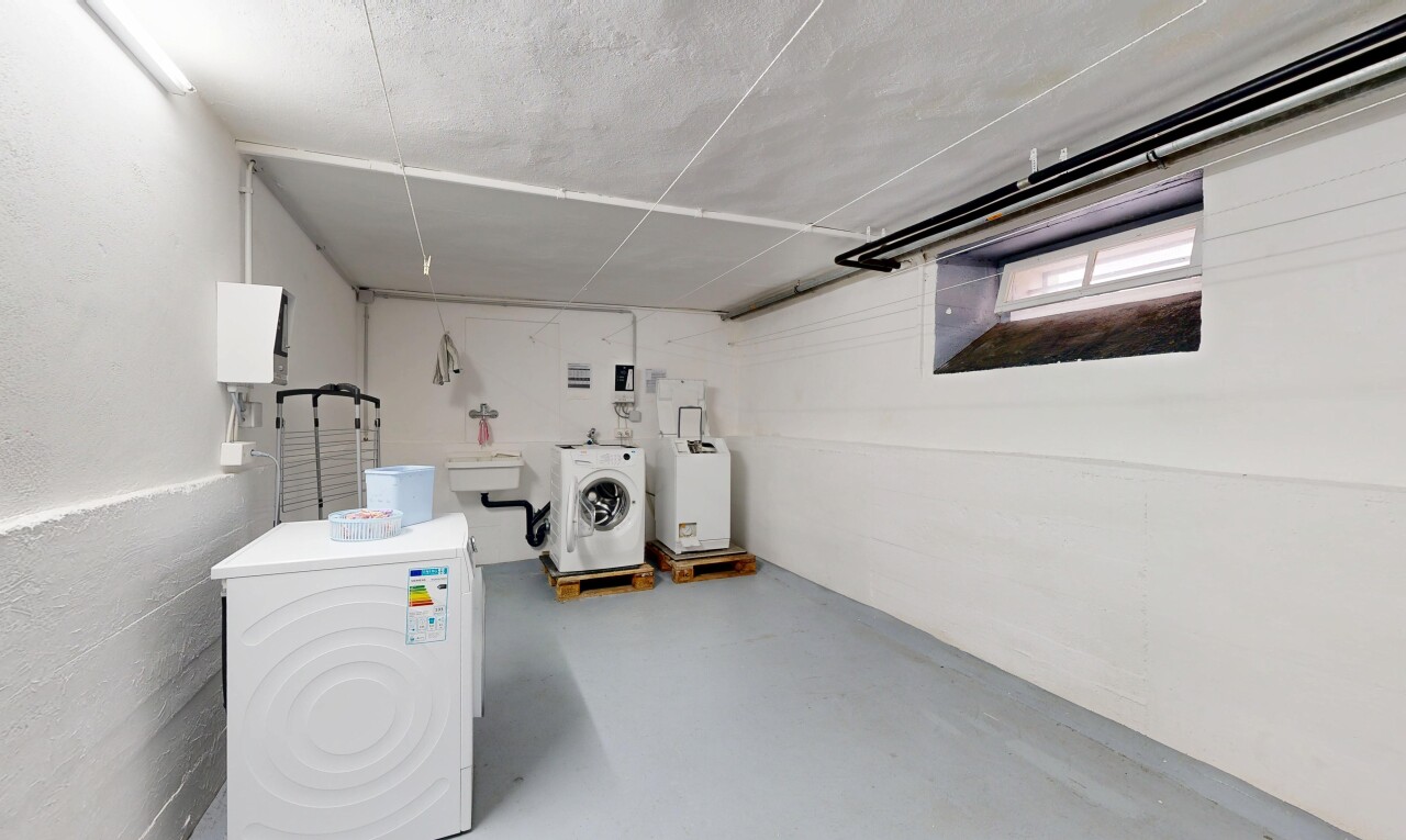 buanderie avec lave-linge et sèche-linge, concrete floor, sol en béton, inside property, et finished concrete floor