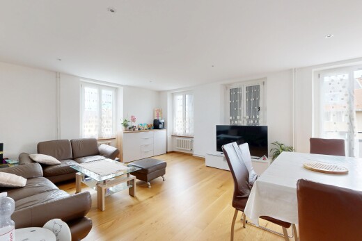 salon / salle à manger avec lumière naturelle, télévision, sol en finition bois, wood finish floor, et cloison sèche