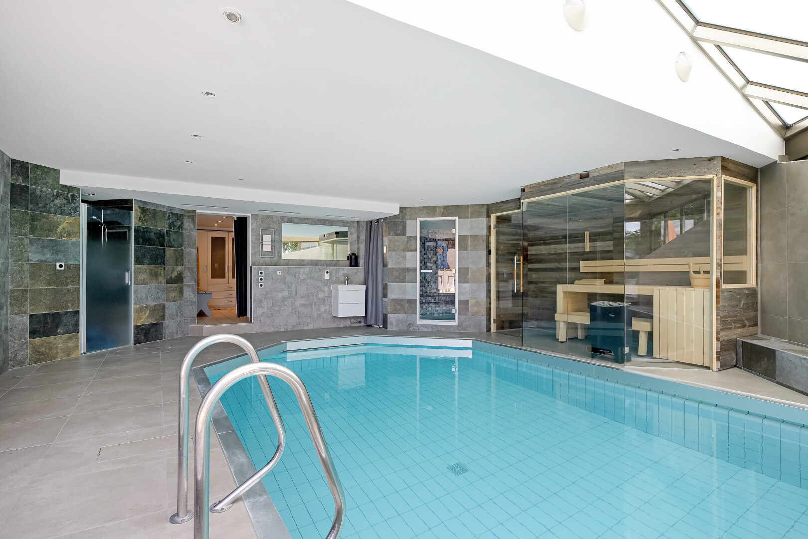 indoor pool featuring a patio and elevator